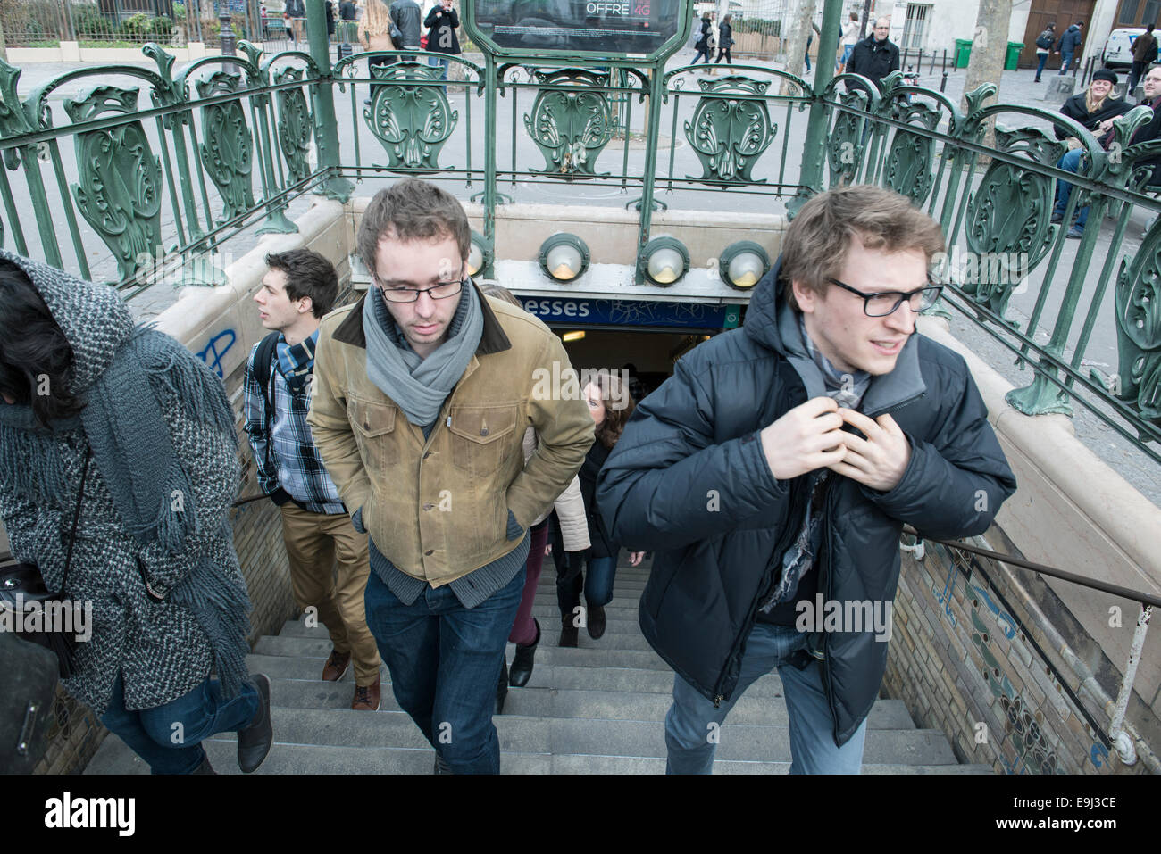 Les touristes et les banlieusards quitter un paris métro gare en hiver avec de grands manteaux sur dus au froid Banque D'Images