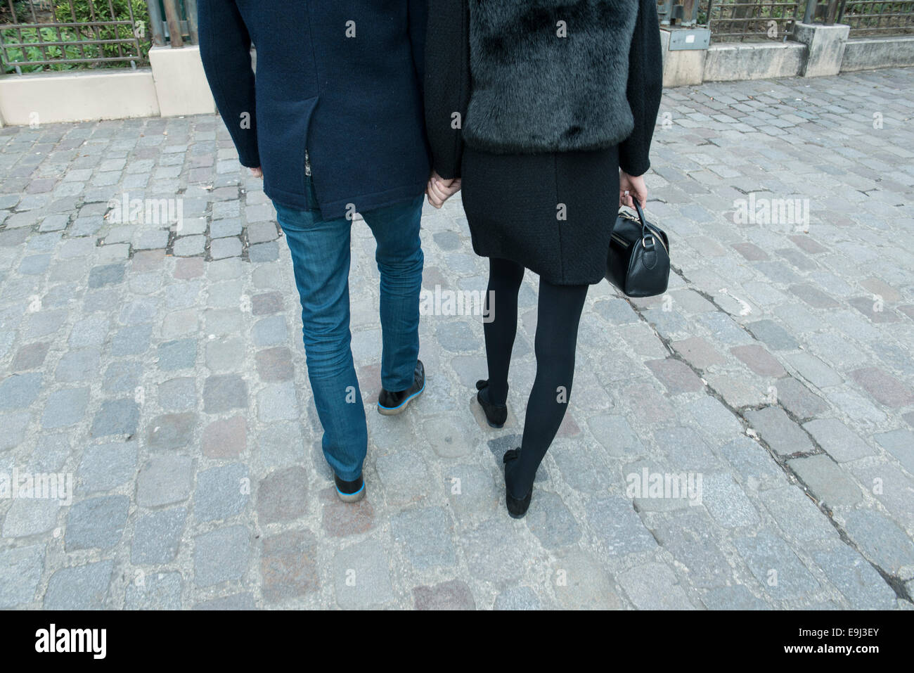 Un jeune couple dans l'amour nous tenir la main tout en marchant sur une rue parisienne vers le mur d'amour destination touristique à Paris le Jour de Valentines Banque D'Images