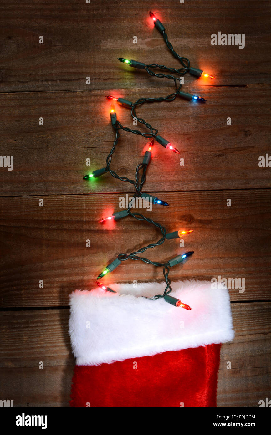 High angle shot d'un bas de Noël sur une surface en bois rustique avec des lumières de Noël qui sort du haut. Format vertical. Banque D'Images