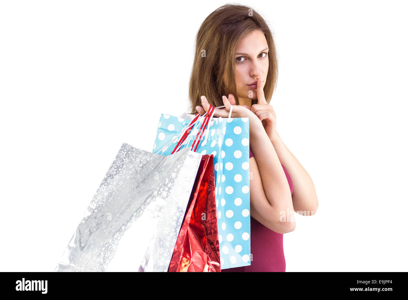 Pretty woman holding shopping bags avec le doigt sur ses lèvres Banque D'Images