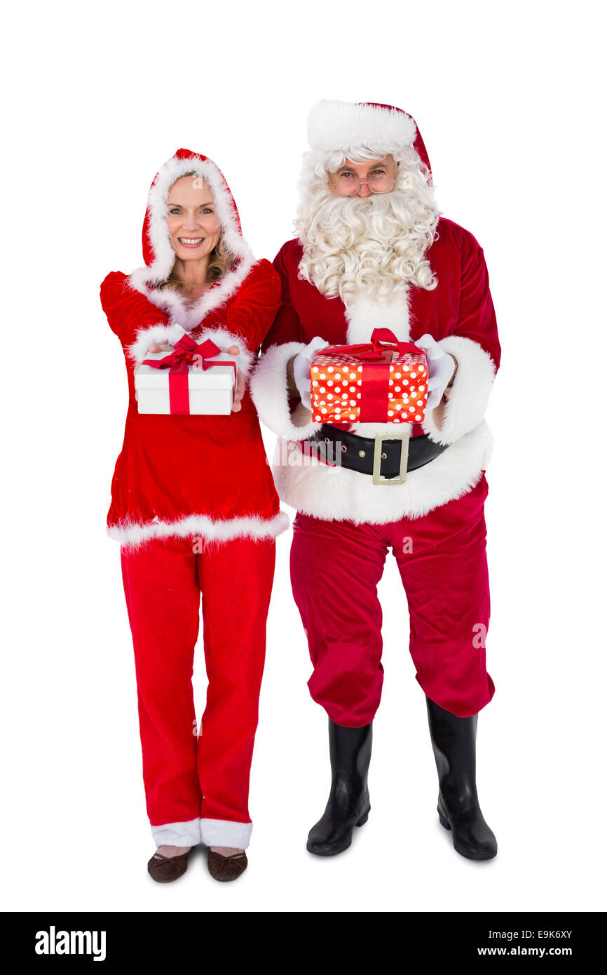 Santa et Mme Noël cadeaux offrant smiling at camera Banque D'Images