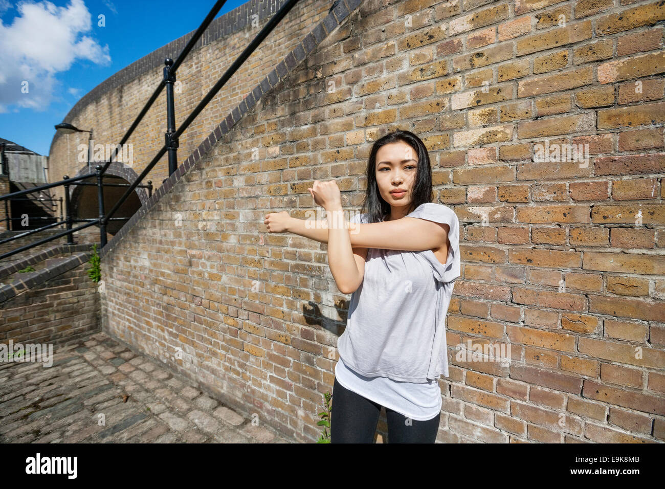 Belle fit woman exercer contre brick wall Banque D'Images
