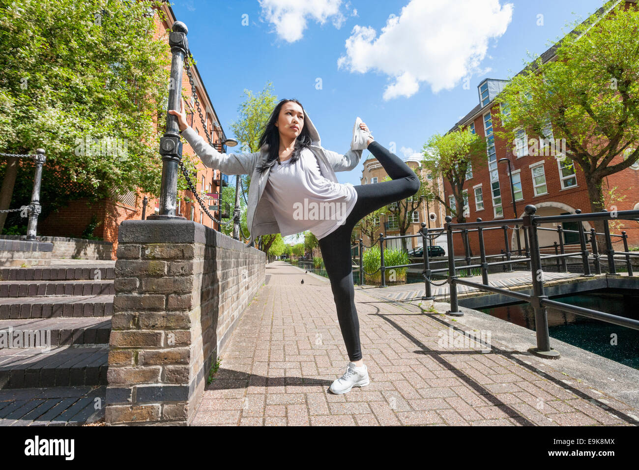 Longueur totale de jeunes fit woman exercising on sidewalk Banque D'Images