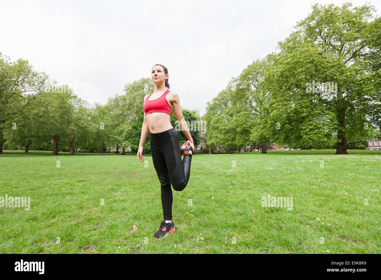 Toute la longueur de fit young woman stretching exercice dans park Banque D'Images