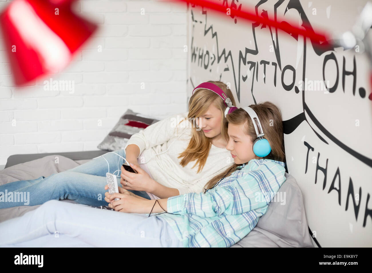 Sœurs détendue l'écoute de musique à la maison Banque D'Images