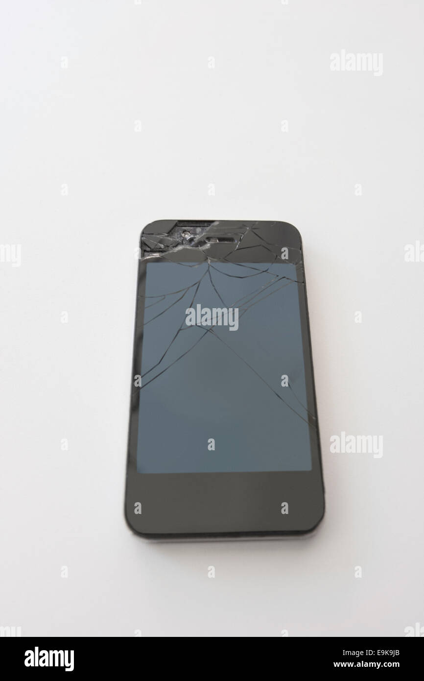 Smart phone avec écran fissuré sur fond blanc Banque D'Images