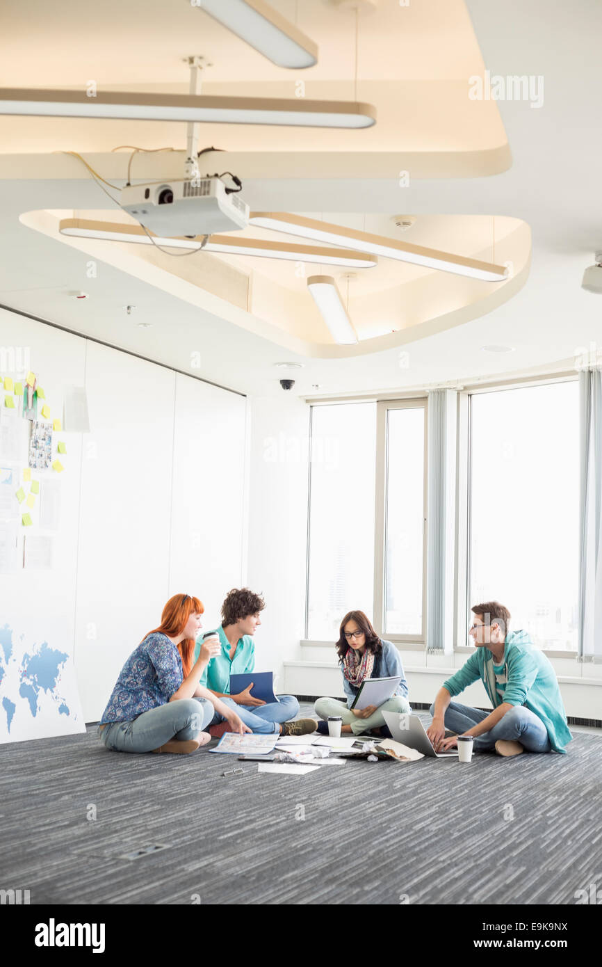 Couple assis sur le plancher en creative office Banque D'Images