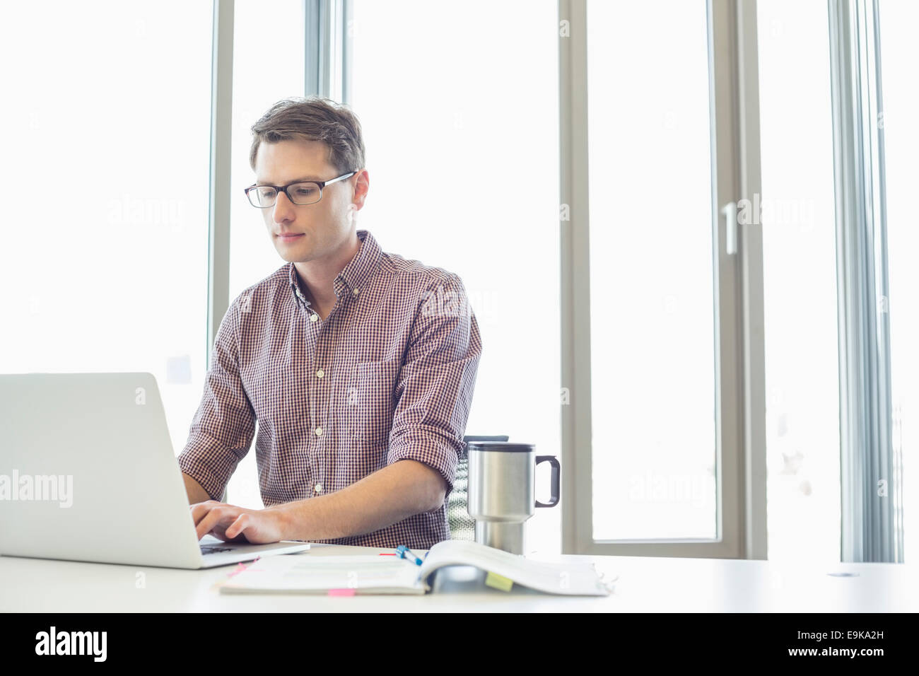 Businessman working on laptop in creative office Banque D'Images