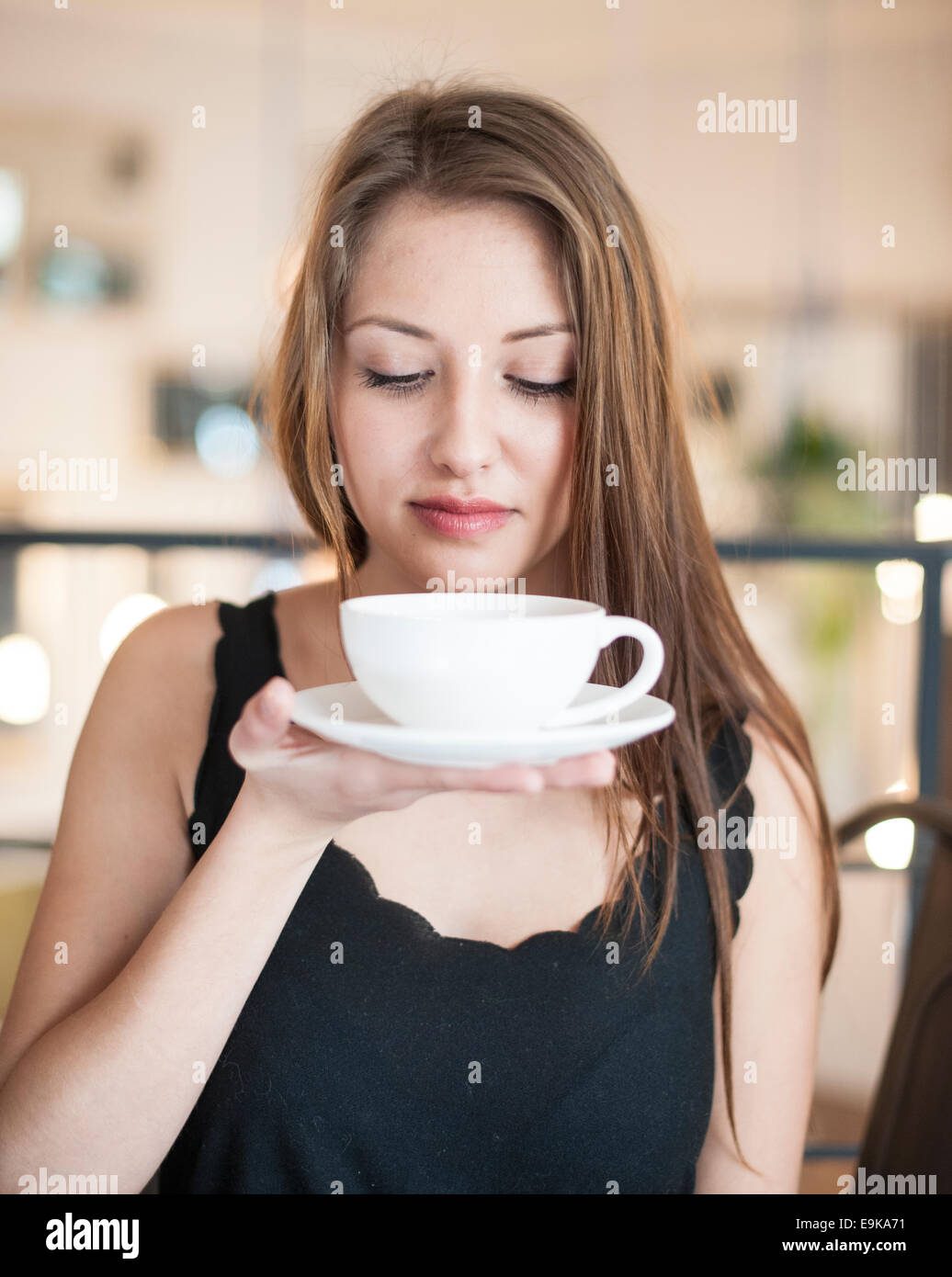 Belle Jeune femme tenant une tasse à café et soucoupe à café Banque D'Images