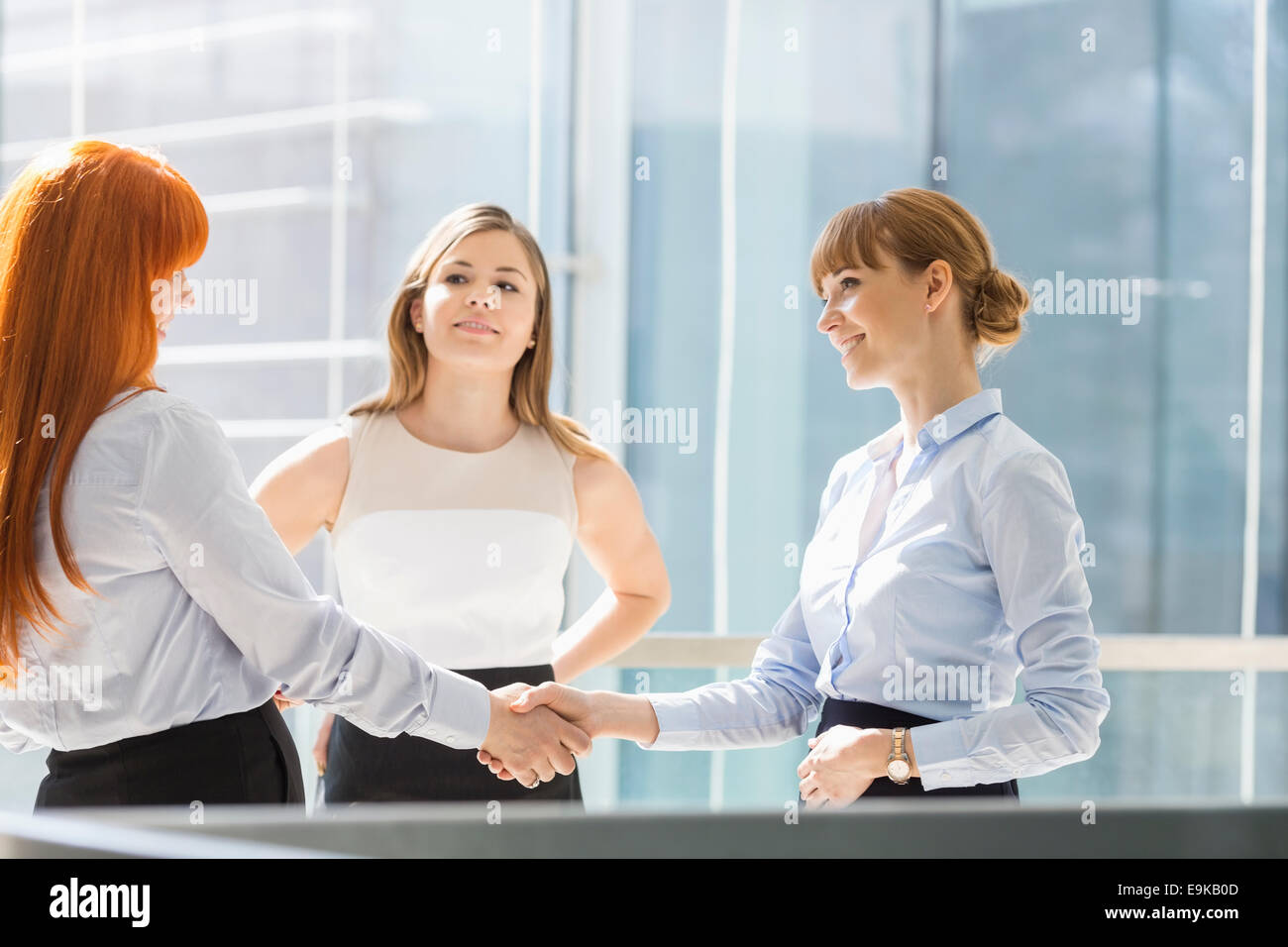 Businesswomen shaking hands in office Banque D'Images