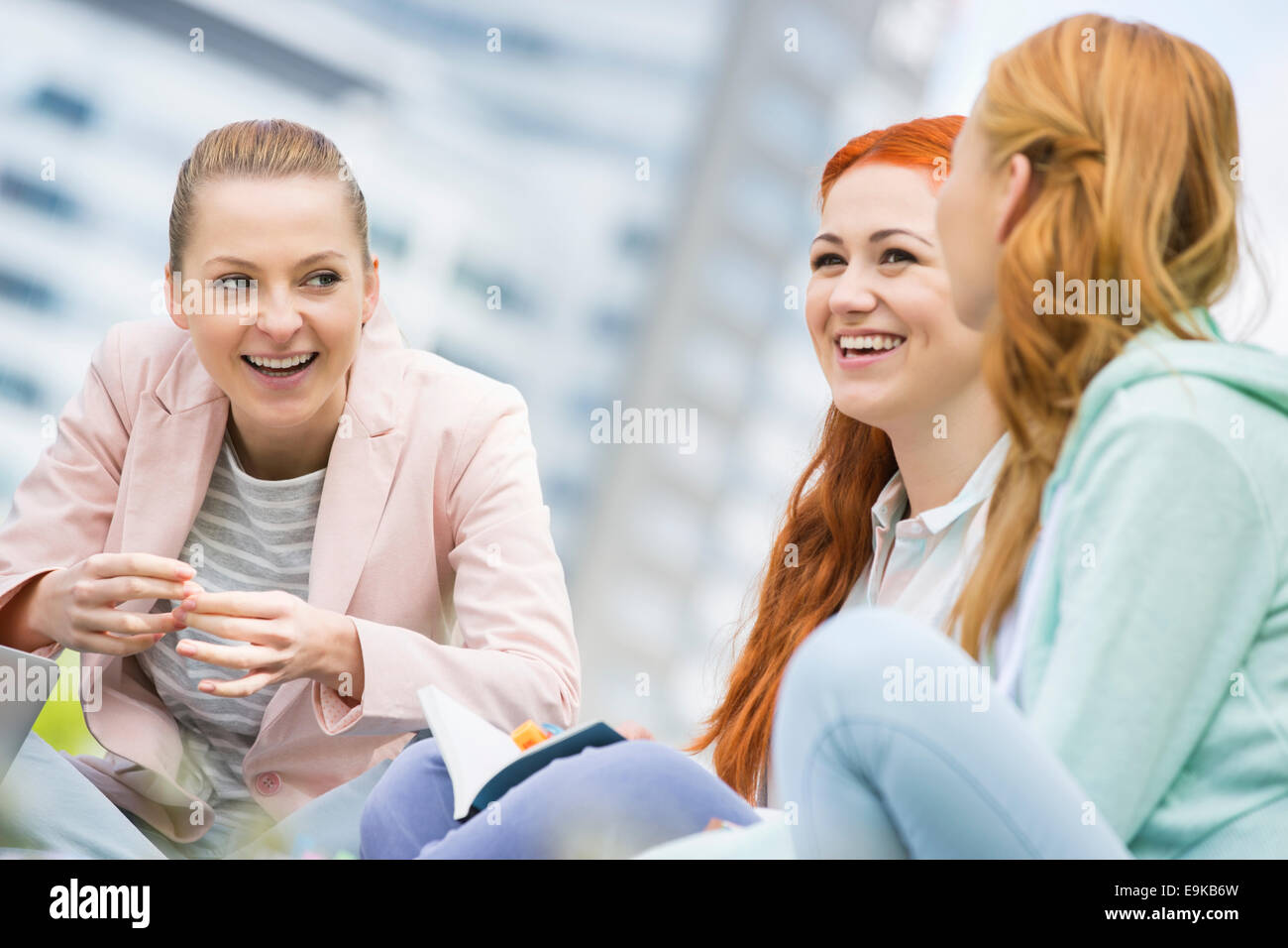 Happy young female college friends studying outdoors Banque D'Images