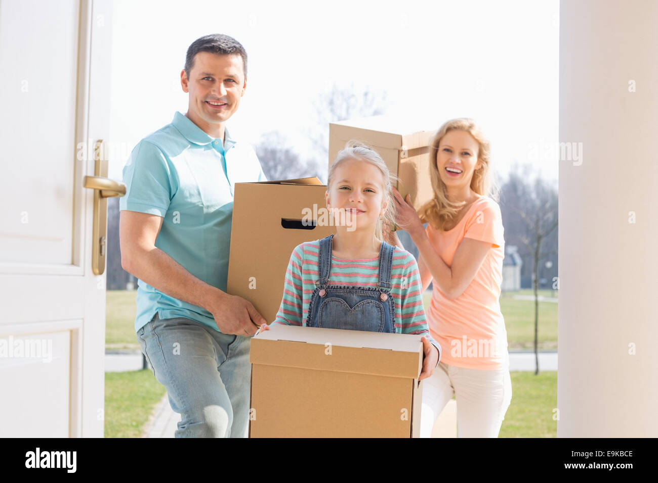 Une famille heureuse avec des boîtes en carton de la saisie de nouvelles home Banque D'Images