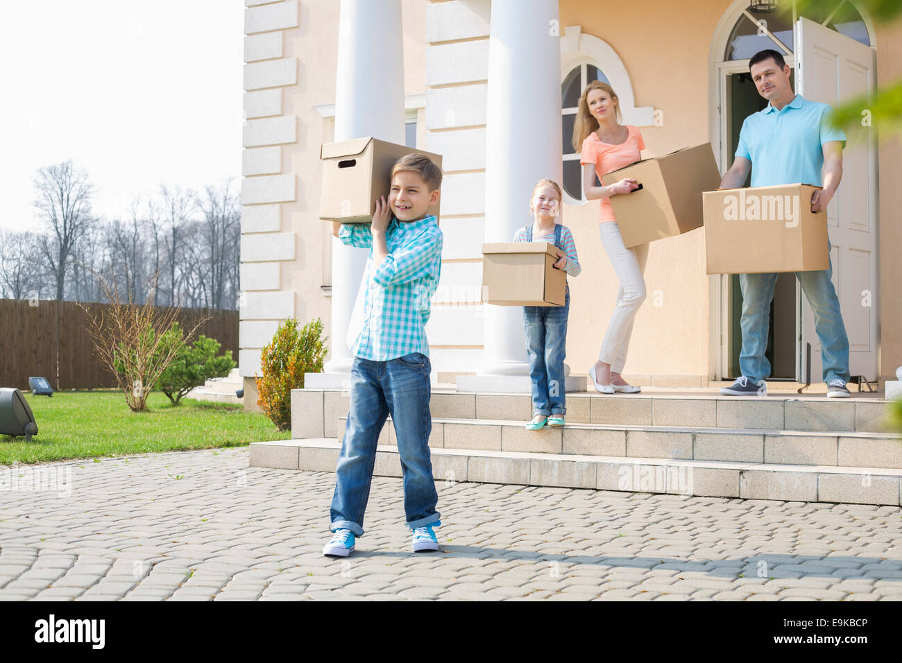 Famille avec boîtes de carton déménagement hors de la maison Banque D'Images