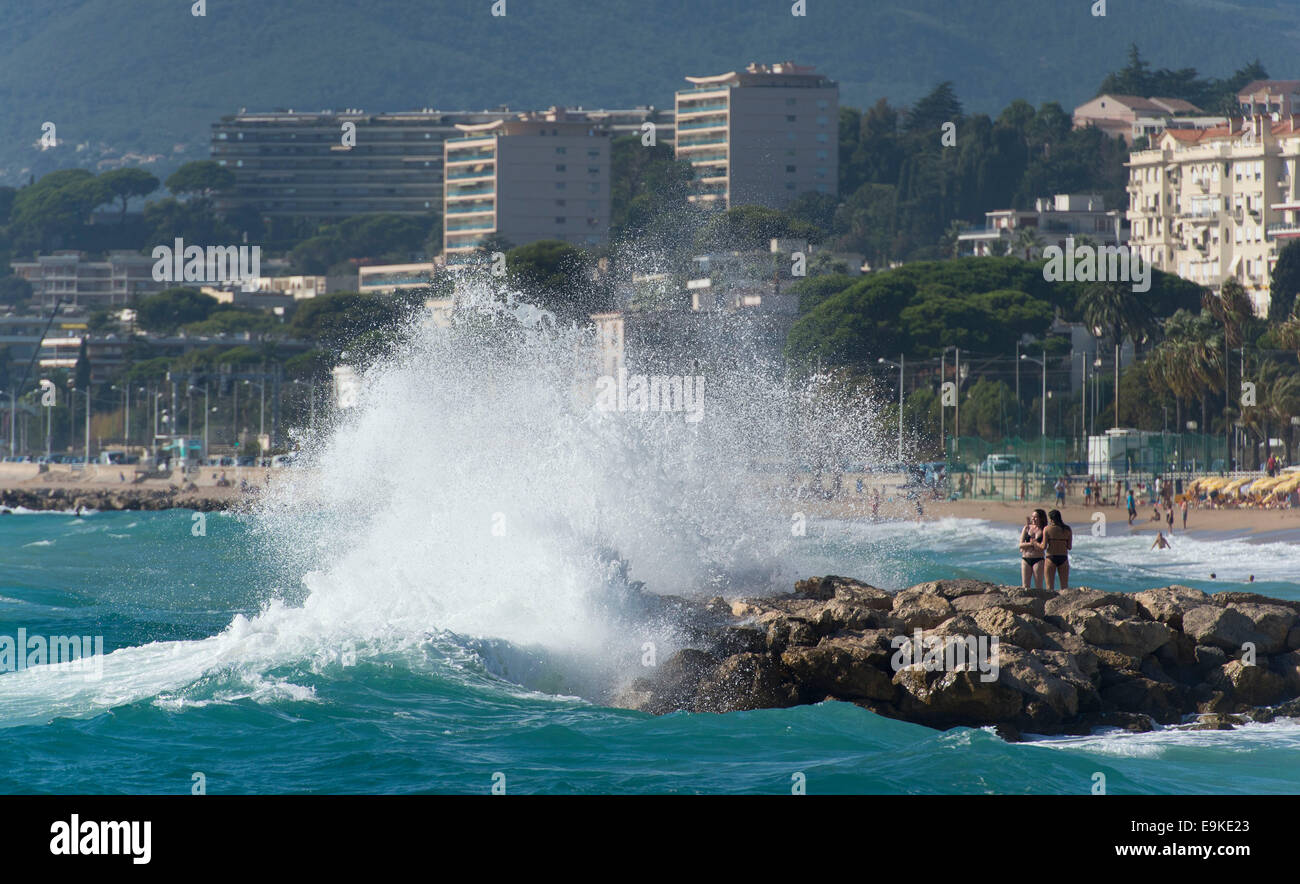 Panne de vagues contre des rochers sur une plage de Cannes, sud de la France. Banque D'Images