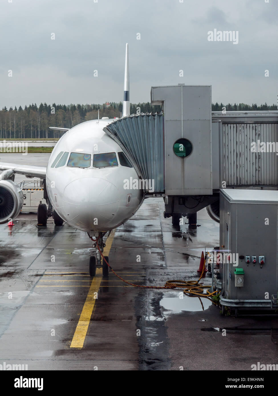 Avion de passagers garé au terminal de l'aéroport avec couloir télescopique attaché pendant que l'embarquement Banque D'Images