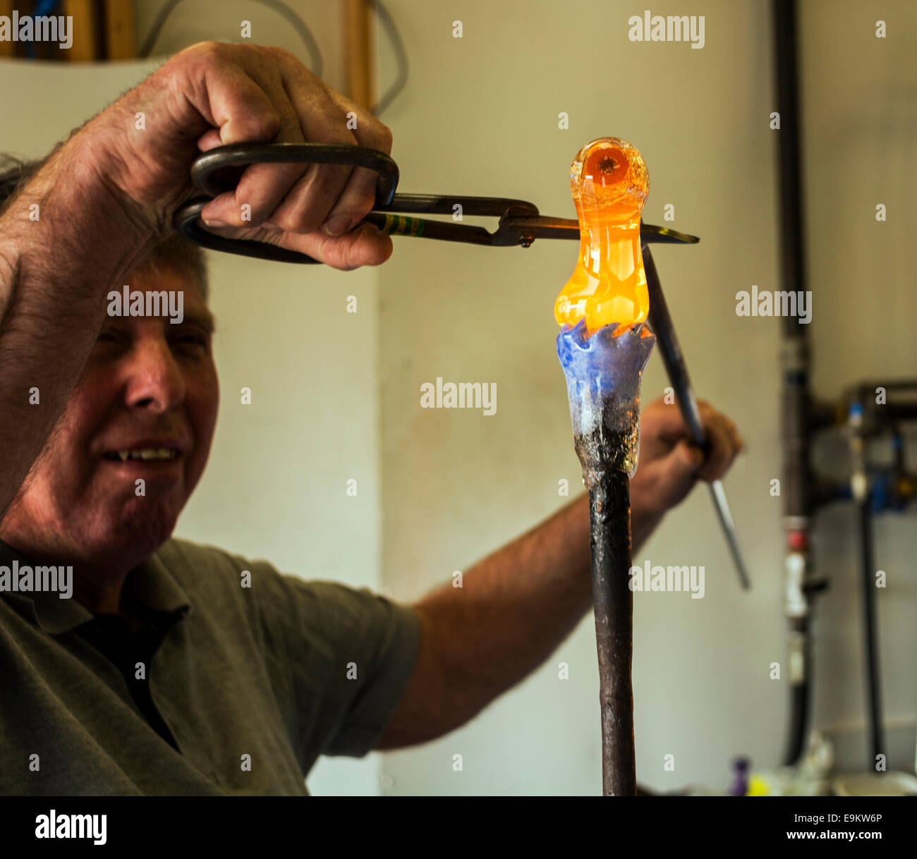 Un artisan qualifié ajoute le verre fondu à un presse-papiers en production, jugeant le montant exact des années d'expérience. Banque D'Images