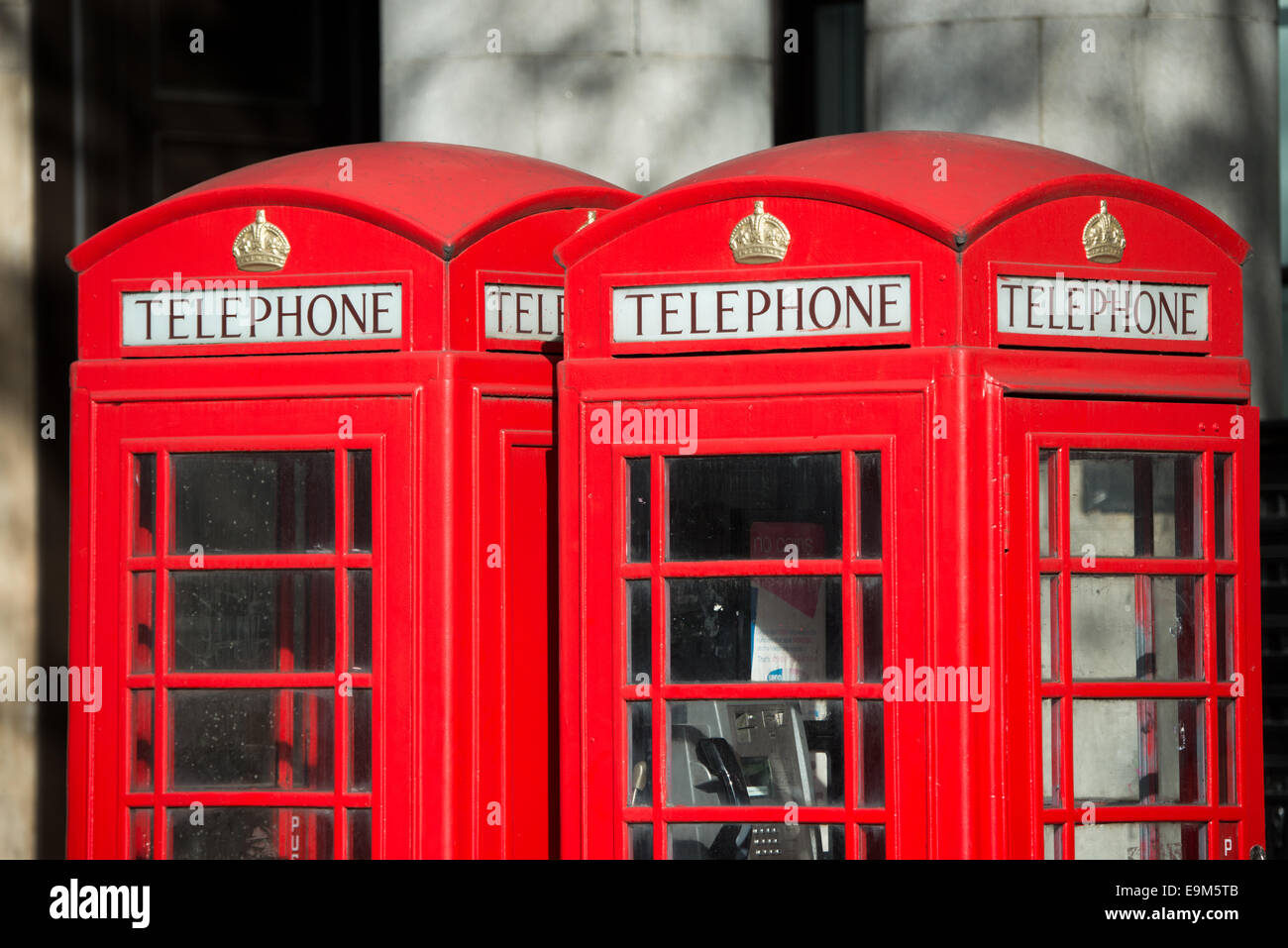 LONDRES, Royaume-Uni — Une cabine téléphonique rouge classique est un symbole emblématique du patrimoine britannique dans une rue londonienne. Malgré la baisse de l'utilisation des téléphones publics payants, ces kiosques distinctifs restent une caractéristique appréciée et reconnaissable du paysage urbain du Royaume-Uni. Banque D'Images