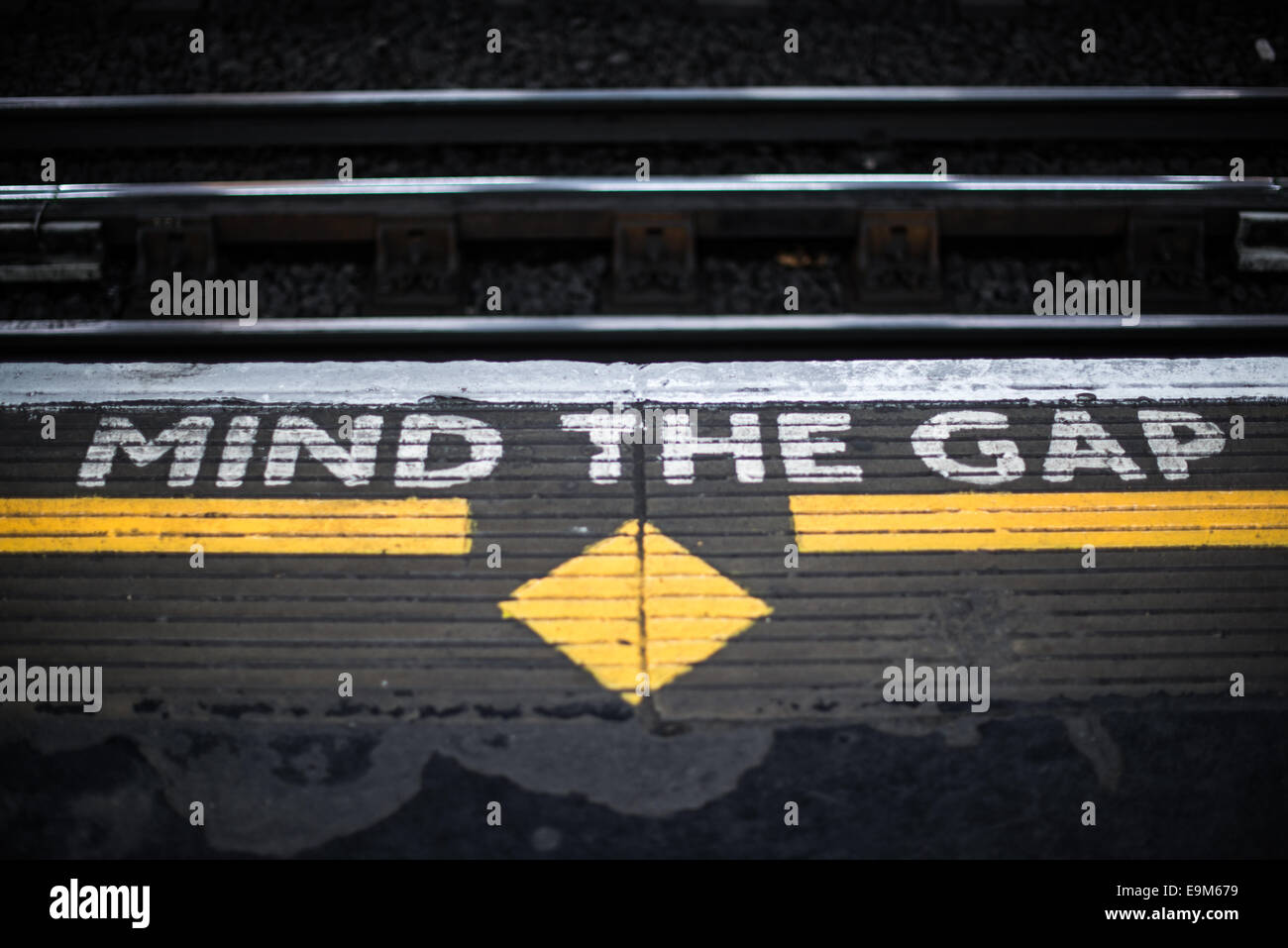 Mind the Gap Sign London Underground Londres Angleterre // LONDRES, Royaume-Uni — des panneaux peints sur une plate-forme du métro de Londres avertissent les passagers de « Mind the Gap » entre le train et la plate-forme lorsqu'ils montent et descendent du train. Cette phrase de sécurité emblématique, introduite en 1969, est devenue l'un des symboles les plus reconnaissables de Londres et une pierre de touche culturelle. Les avertissements sont particulièrement importants dans les gares courbes où des écarts importants peuvent se former entre les trains et les quais. Le métro de Londres, communément connu sous le nom de The tube, est le plus ancien système ferroviaire souterrain du monde, ayant ouvert en 1 Banque D'Images