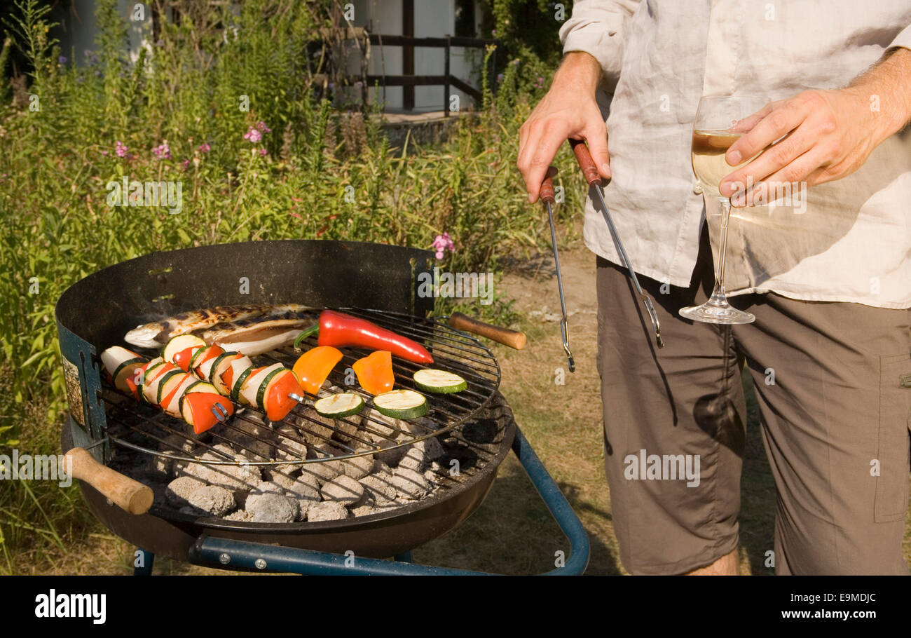 La cuisine de l'homme poisson et légumes brochettes sur le barbecue grill Banque D'Images