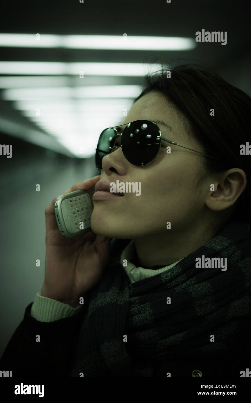 Close-up of mid adult woman using mobile phone in tunnel Banque D'Images