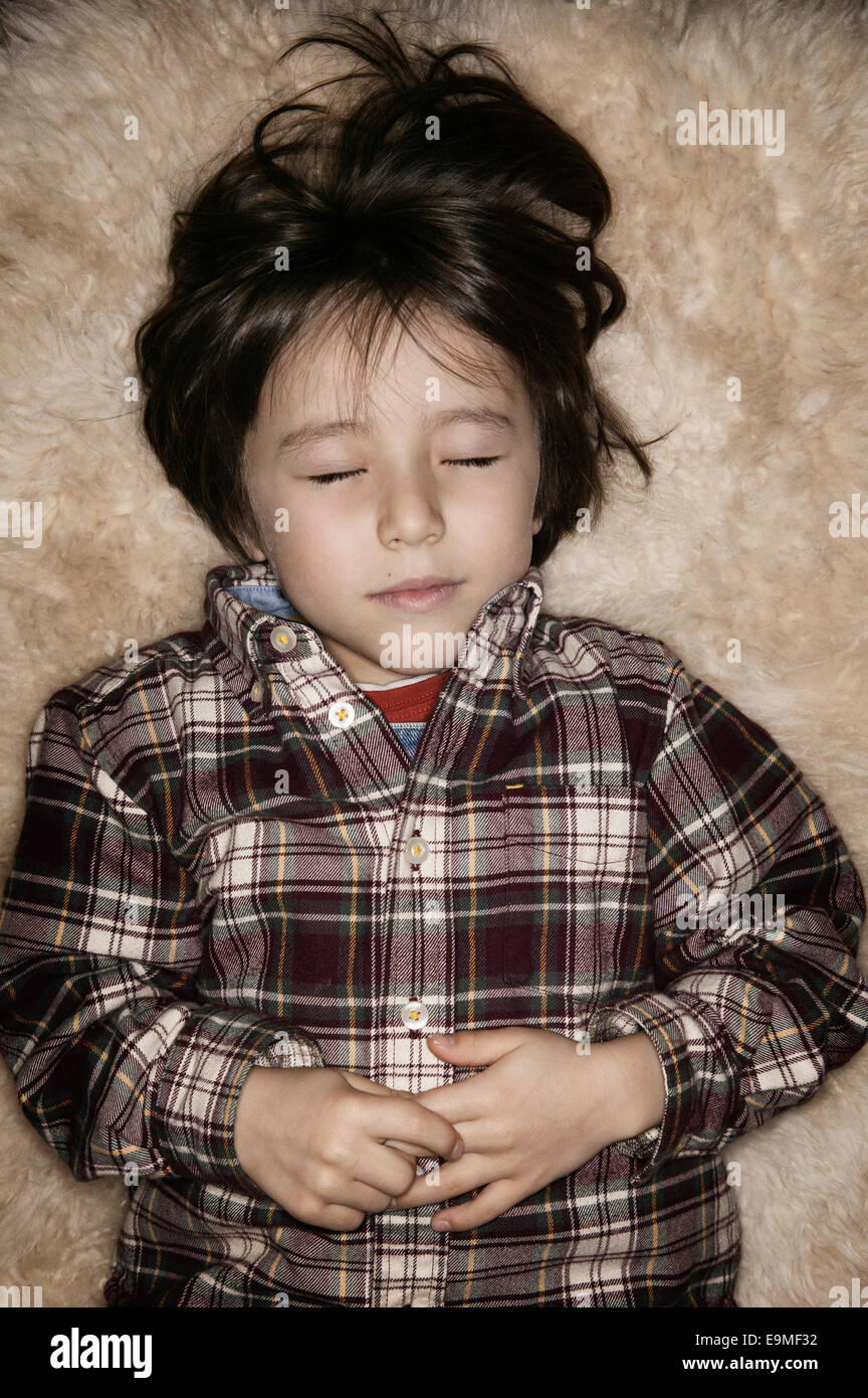 Cute boy dormir sur un tapis Banque D'Images