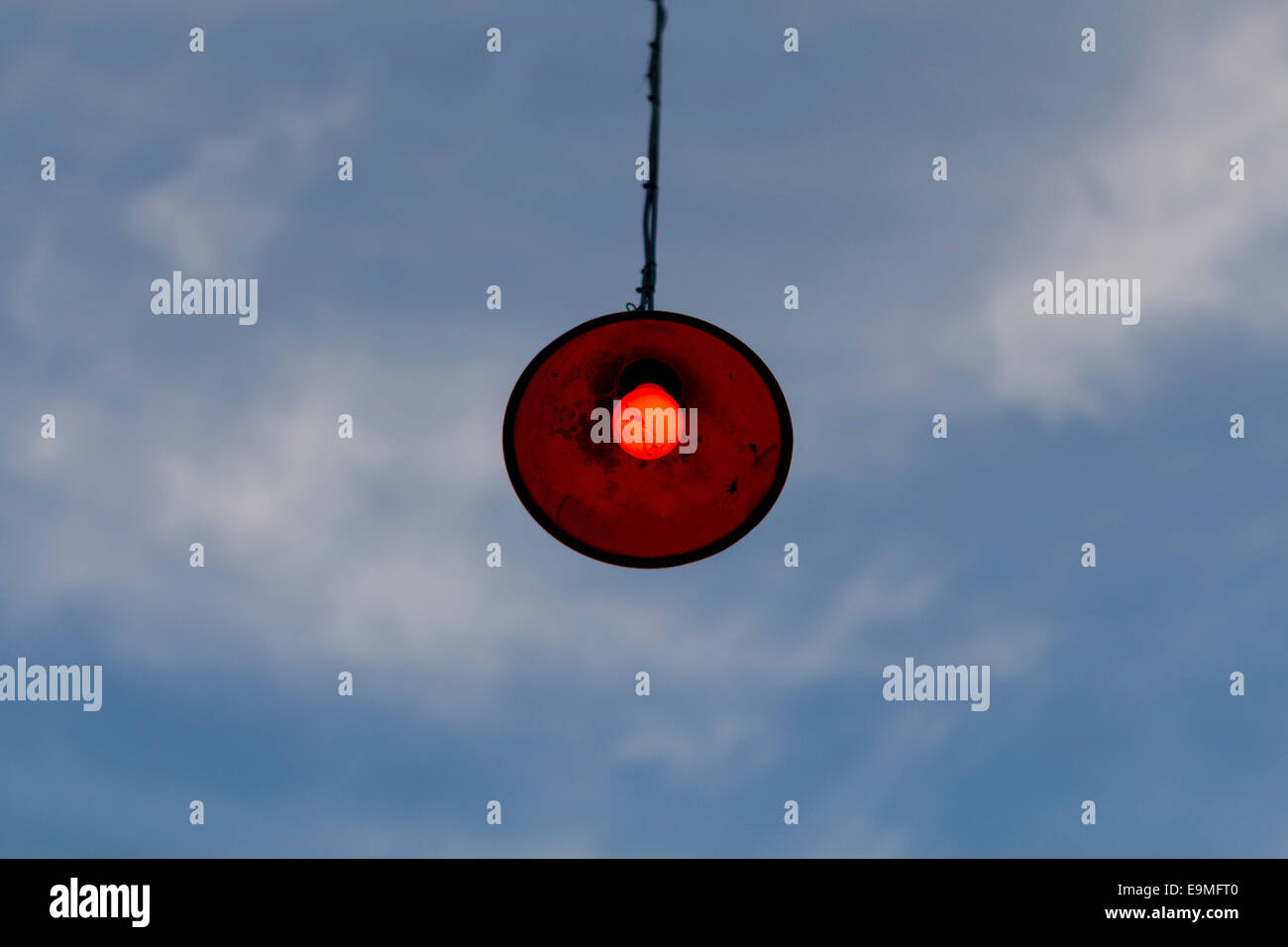 Low angle view of lamp hanging against cloudy sky Banque D'Images