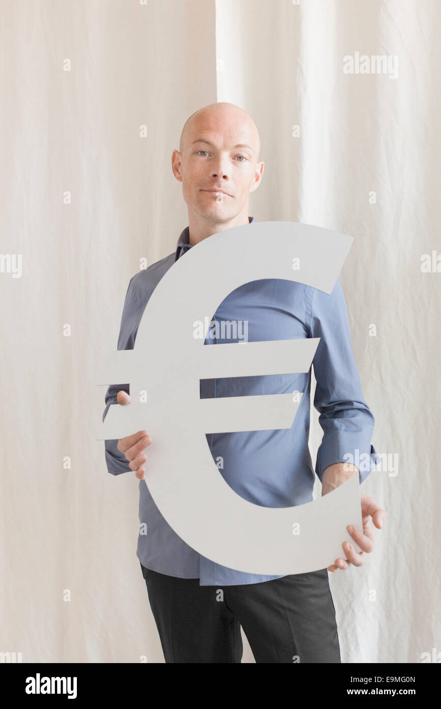 Portrait of businessman holding symbole euro at office Banque D'Images