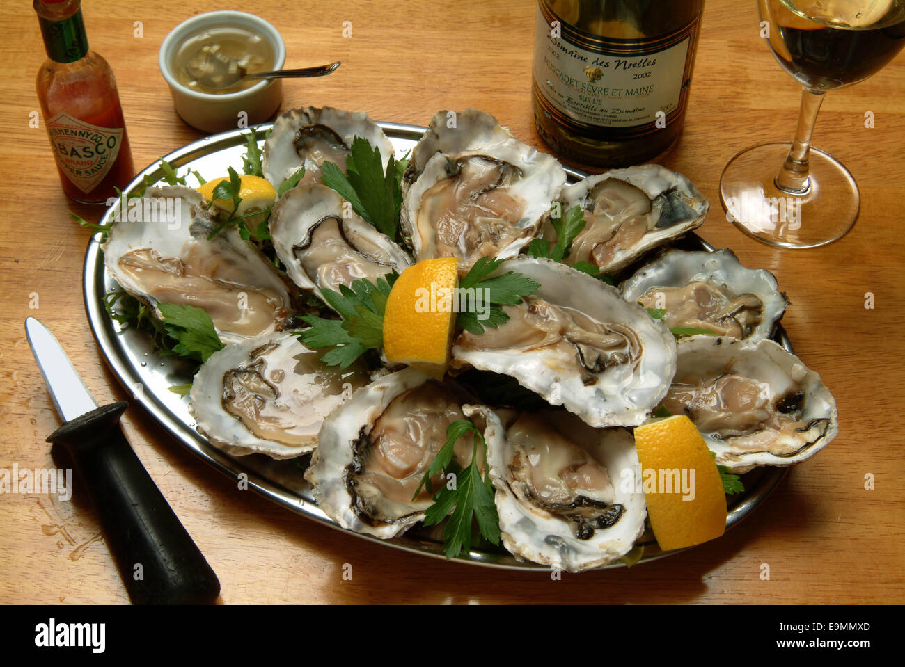 Pêche à l'huître dans l'estuaire de FAL, Cornouailles, Royaume-Uni. Huîtres servies avec sauce tobasco. Banque D'Images