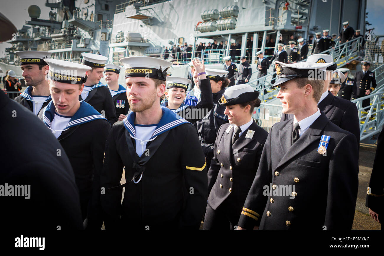 Un marin femmes vagues comme elle repère lors du débarquement de la famille de la Type 23 frégate HMS Westminster retour à Portsmouth Banque D'Images