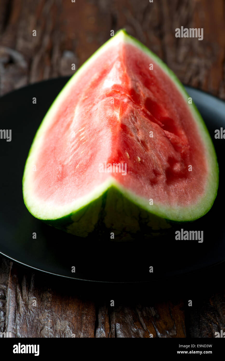 La pastèque rouge sur la plaque de table en bois Banque D'Images