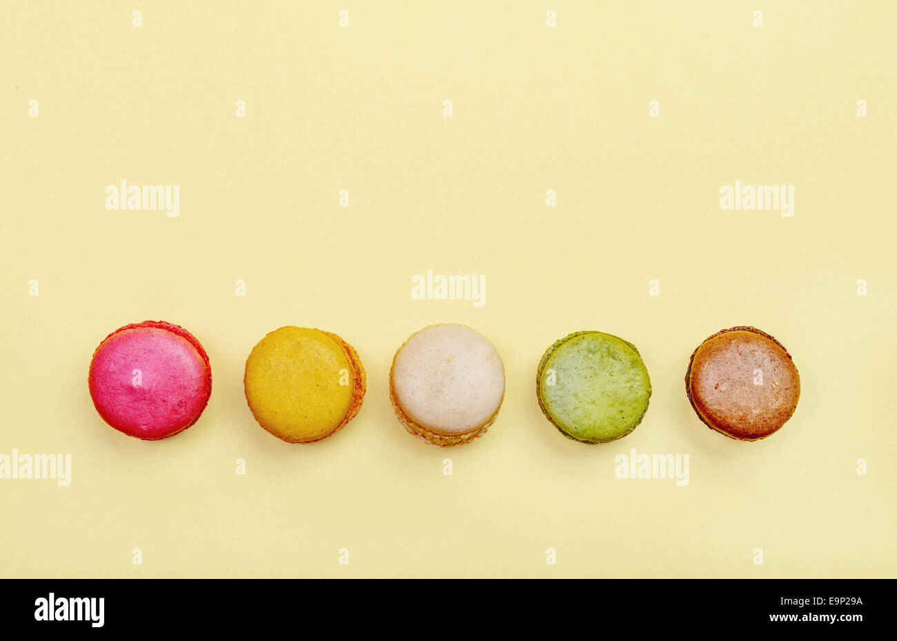 Colorés et savoureux Macarons français sur fond jaune.vue d'en haut. Banque D'Images