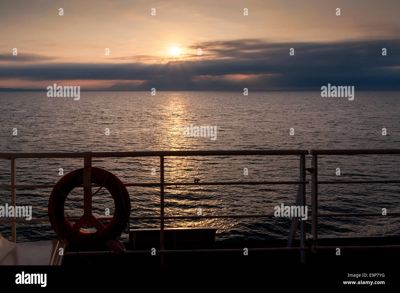 Bouée de bateau avec le soleil sur le point de couler au-dessous de l'horizon Banque D'Images