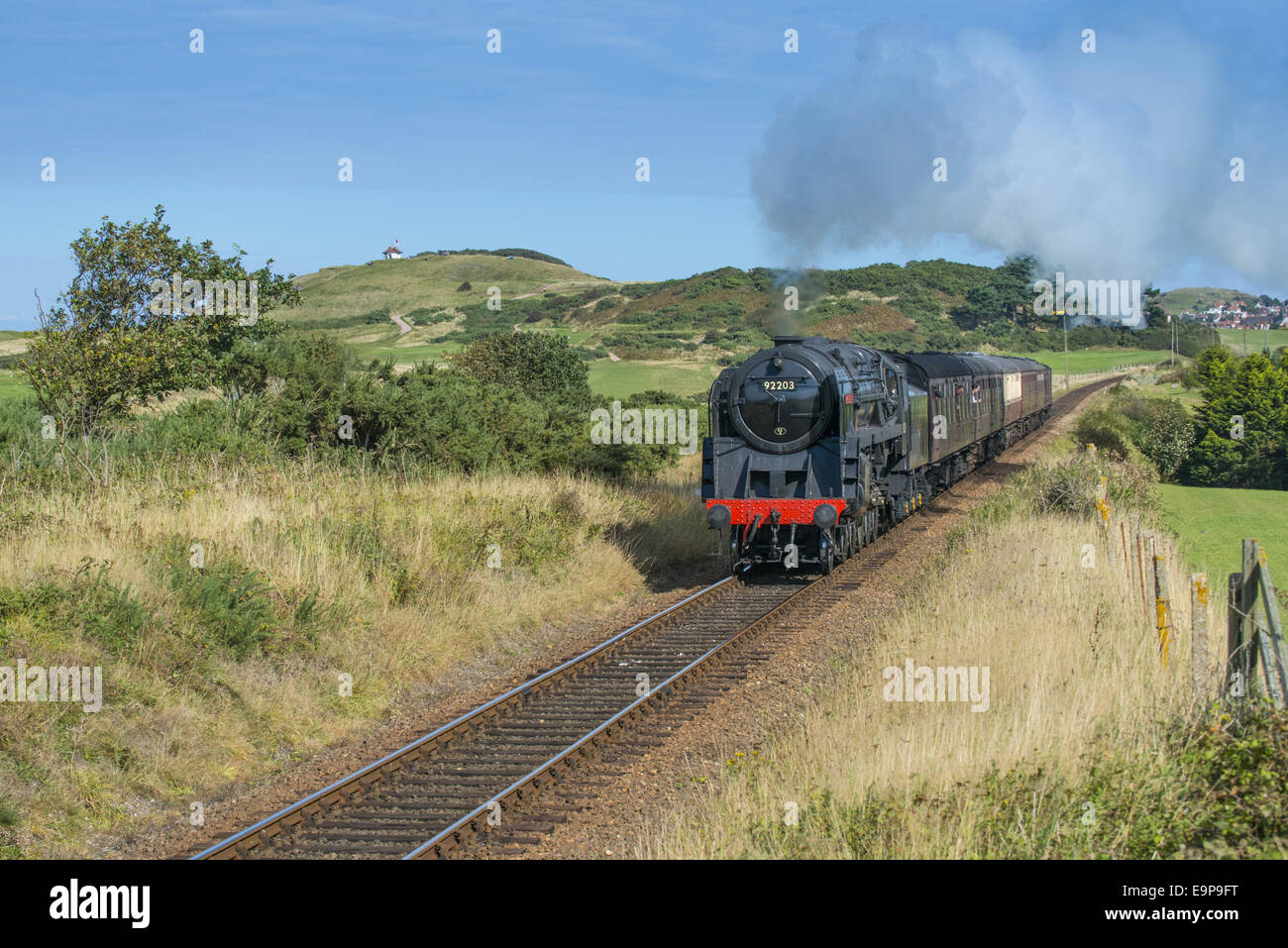 Train à vapeur et des voitures de golf, en passant par la ville balnéaire avec en arrière-plan, North Norfolk Railway, Sheringham, Norfolk, Angleterre, Août Banque D'Images