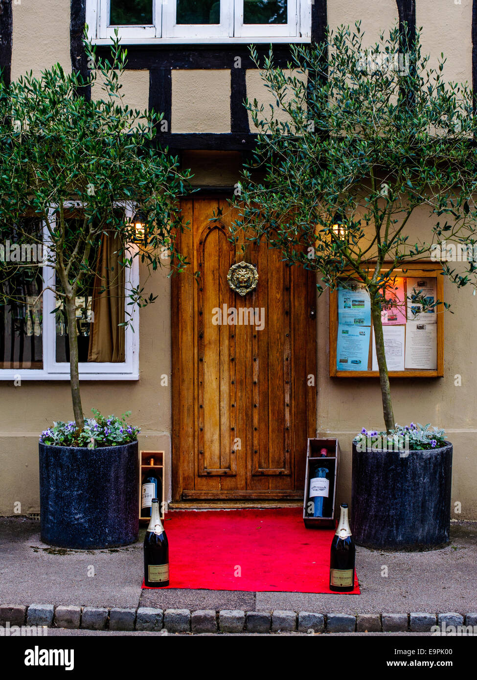 Porte en bois avant de restaurant agréable avec tapis rouge des bouteilles de Champagne. Essex Banque D'Images