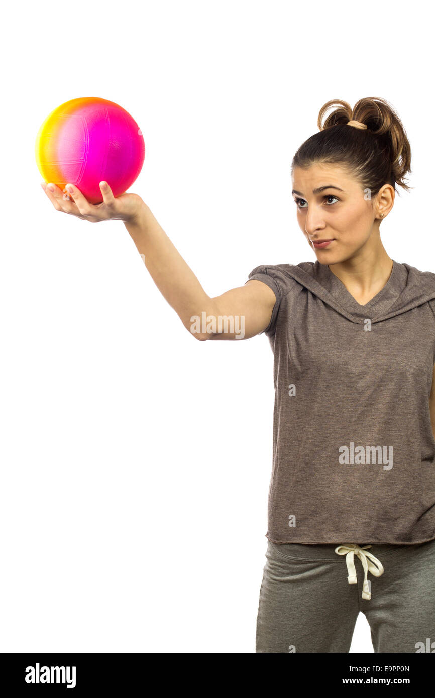 Jeune femme à la recherche jusqu'à une boule colorée sur fond blanc Banque D'Images