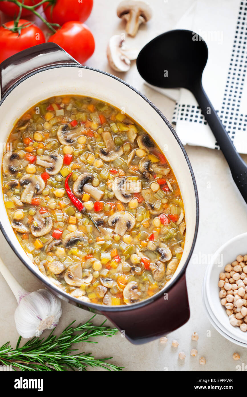 Soupe avec les pois chiches, les champignons et les légumes en casserole en fonte Banque D'Images