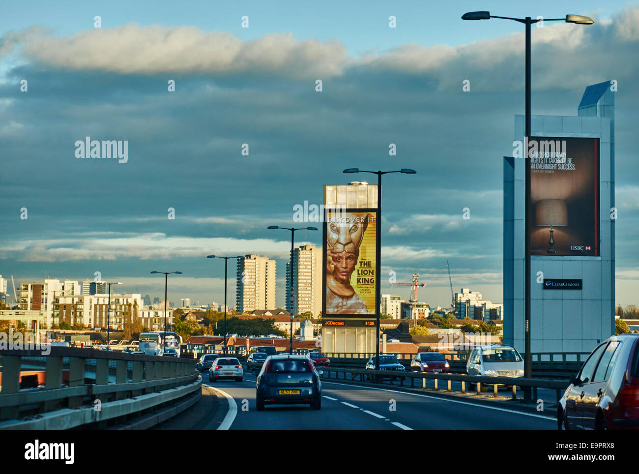 Le trafic important, des bâtiments et de l'affiche du Roi Lion, baigné de soleil chaud début de soirée, à partir de l'autoroute M4 près de Chiswick, à l'ouest de Londres, Angleterre, Royaume-Uni. Banque D'Images