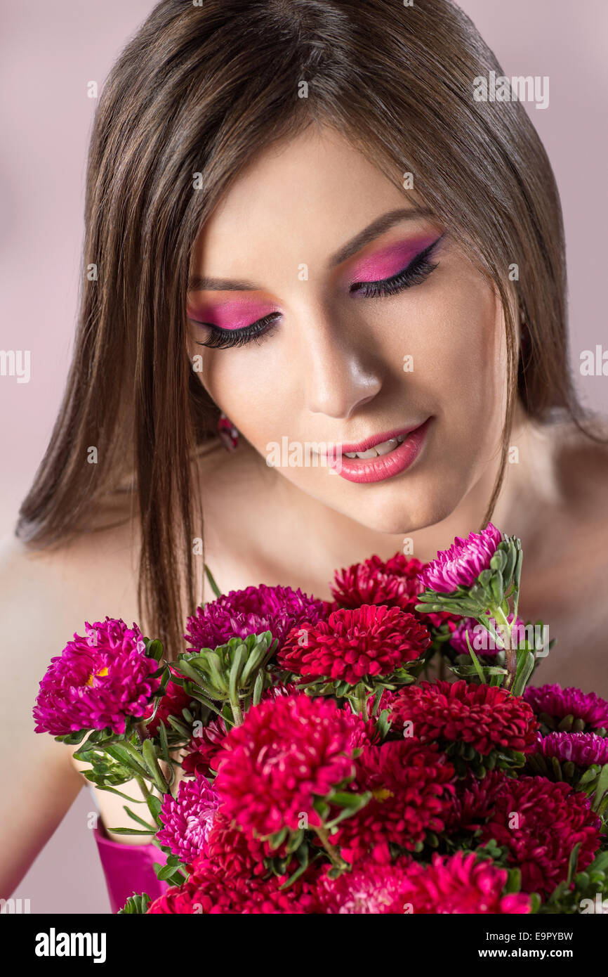 Belle Femme en rose avec des fleurs maquillage Banque D'Images