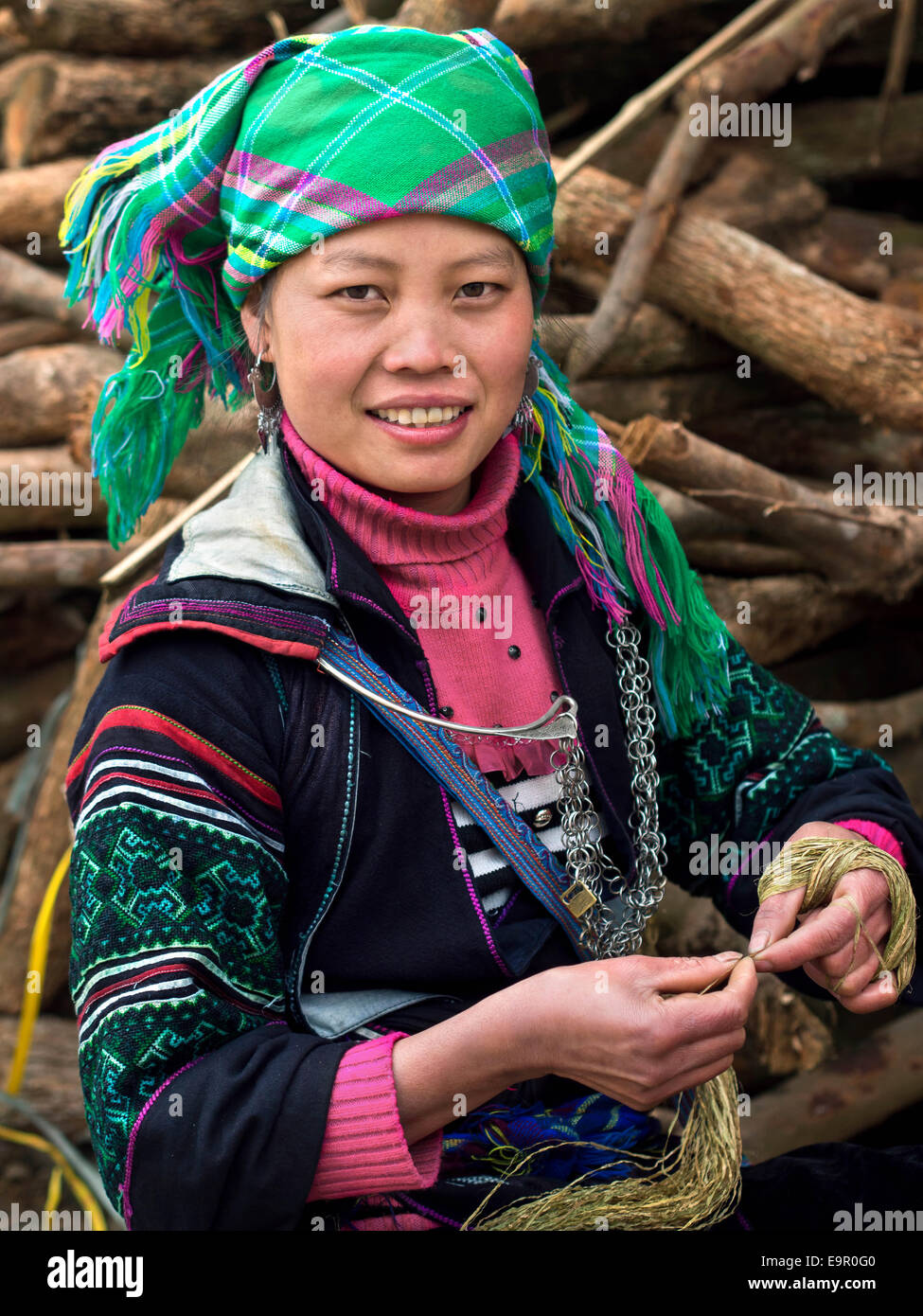 Femme Hmong noirs habillés en costumes traditionnels et de travail avec du fil au village Ta Van, près de Sapa, Vietnam du Nord. Banque D'Images