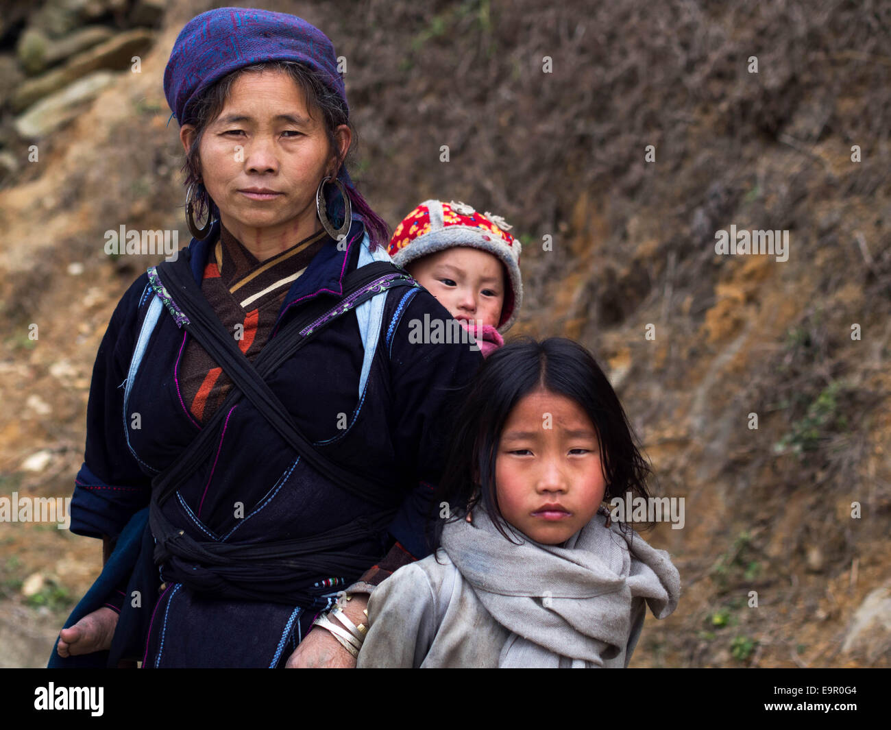 Femme Hmong portant des vêtements traditionnels, avec bébé et des jeunes fille sur la piste en direction du village Ta Van près de Sapa, SAPA, Vietnam. Banque D'Images