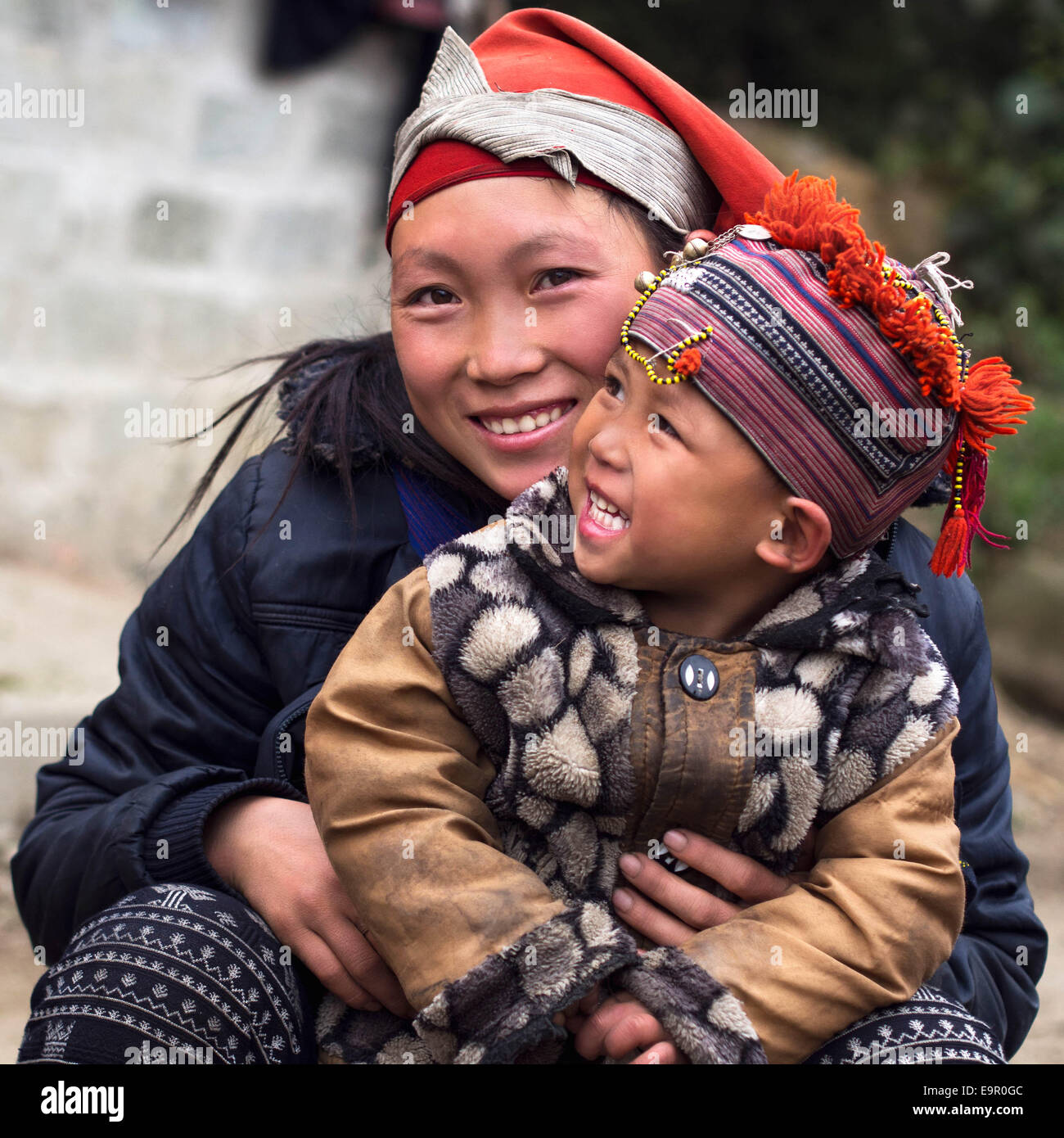 Femme et enfant Hmong heureux souriant, assis dehors à Giang Ta Chai, village près de la ville de Sapa, province de Lao Cai, Vietnam. Banque D'Images