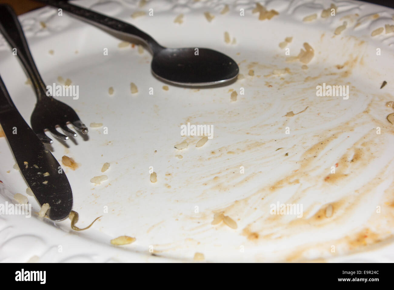 Couteau, fourchette et cuillère sur une plaque vide après avoir mangé un repas dont le riz. Banque D'Images