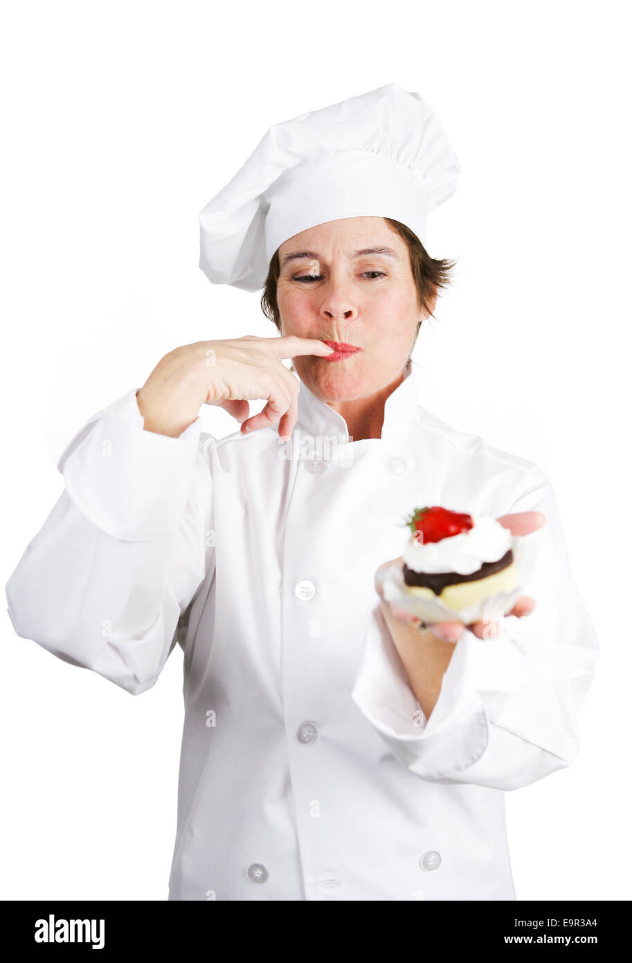 Jolie pâtissier dans les blancs du chef d'une dégustation de délicieux gâteau au fromage au Chocolat Tarte fine à la crème chantilly et une cerise sur le dessus. Isola Banque D'Images