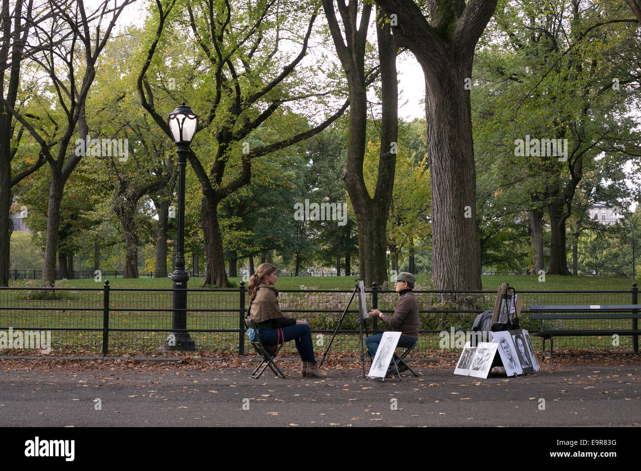 Une femme assise pour un portrait dessin le long du Mall à Central Park, New York City. Banque D'Images