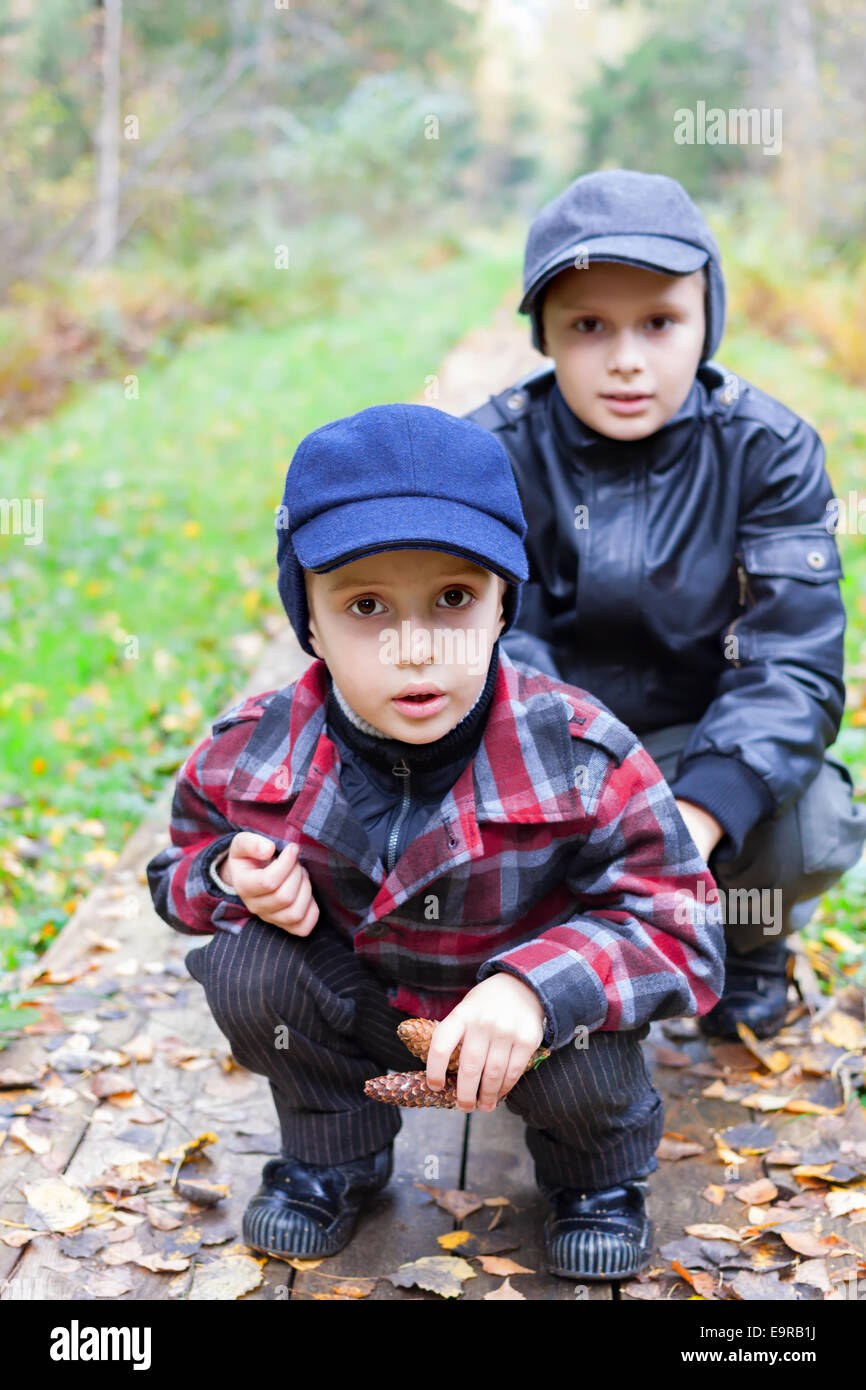 Deux garçons frères route forêt automne sit Banque D'Images