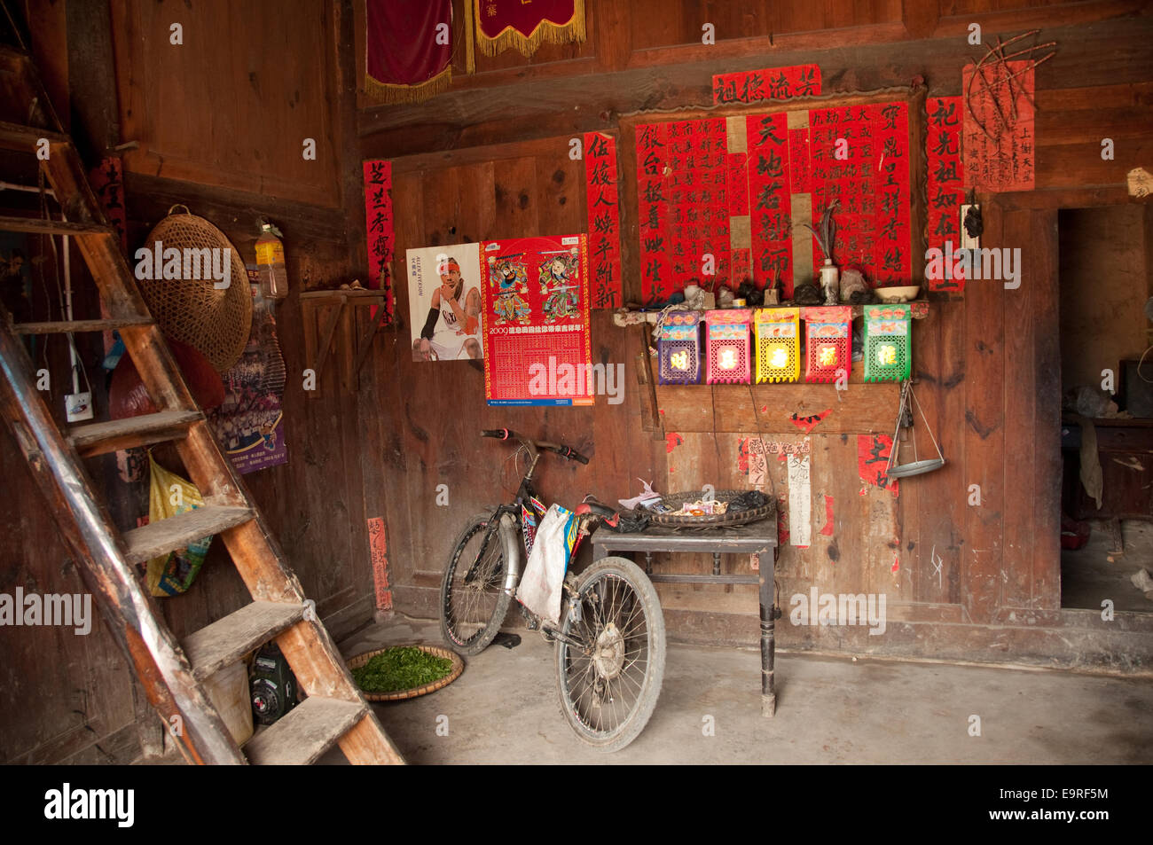 Un vélo et un Allen Iverson poster près d'autel familial, matang, province de Guizhou, Chine Banque D'Images