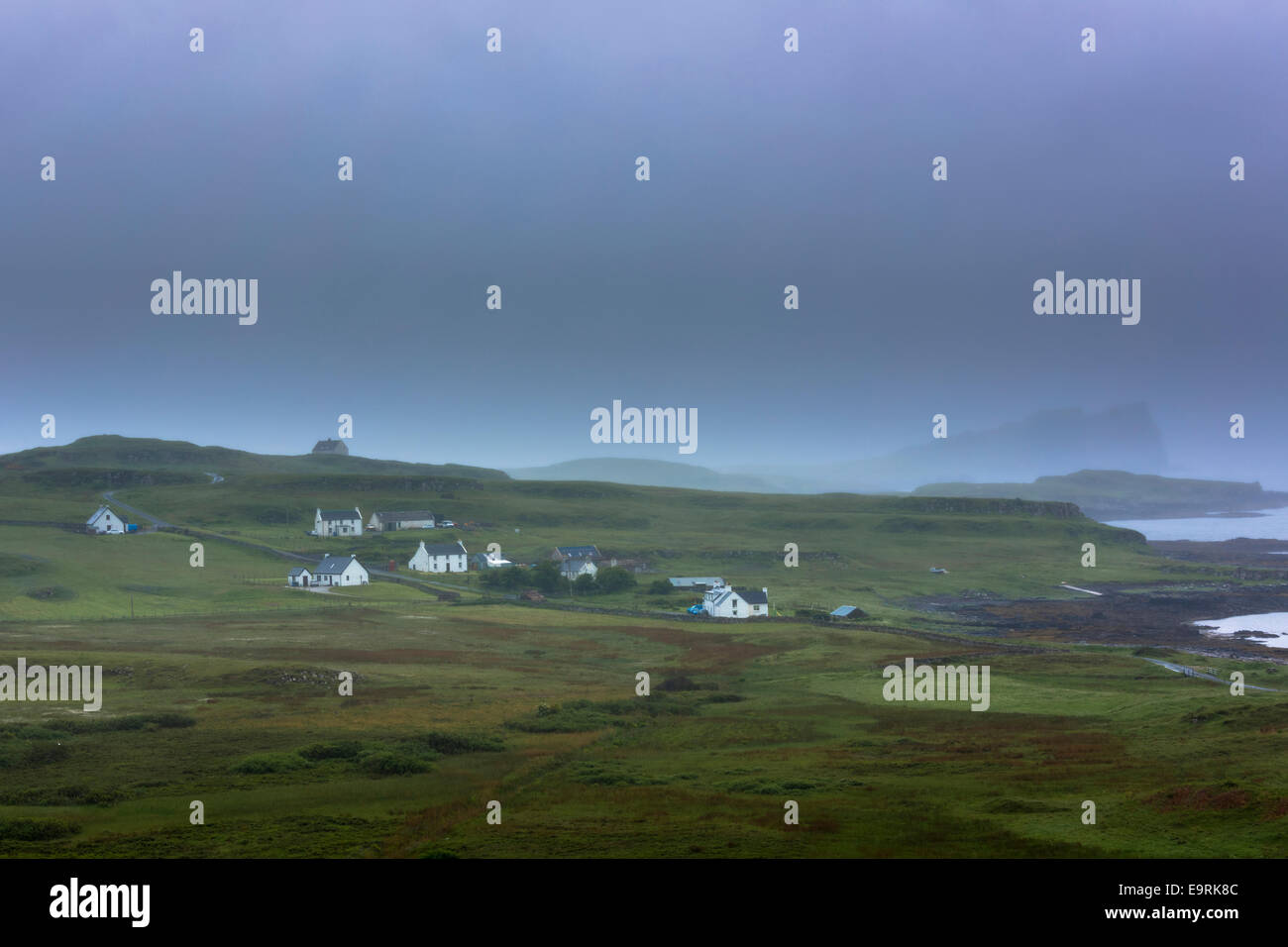 Croft blanchis pittoresques cottages en hameau niché par le rivage sur un ciel gris brumeux journée sur l'île de Skye, Western Isles Banque D'Images