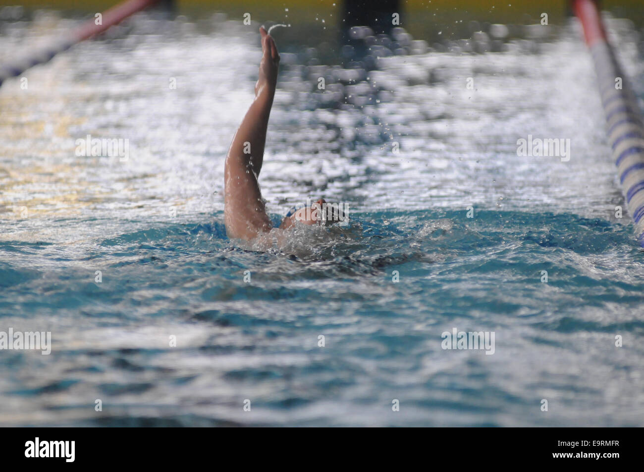 Un jeune garçon backstroking dans le style à un swim meet junior Banque D'Images