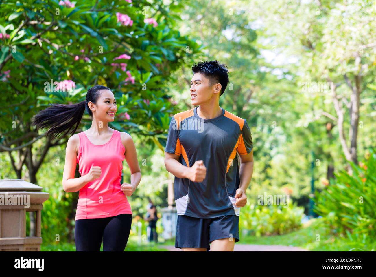 Chinois asiatique l'homme et la femme en jogging du parc de la ville Banque D'Images