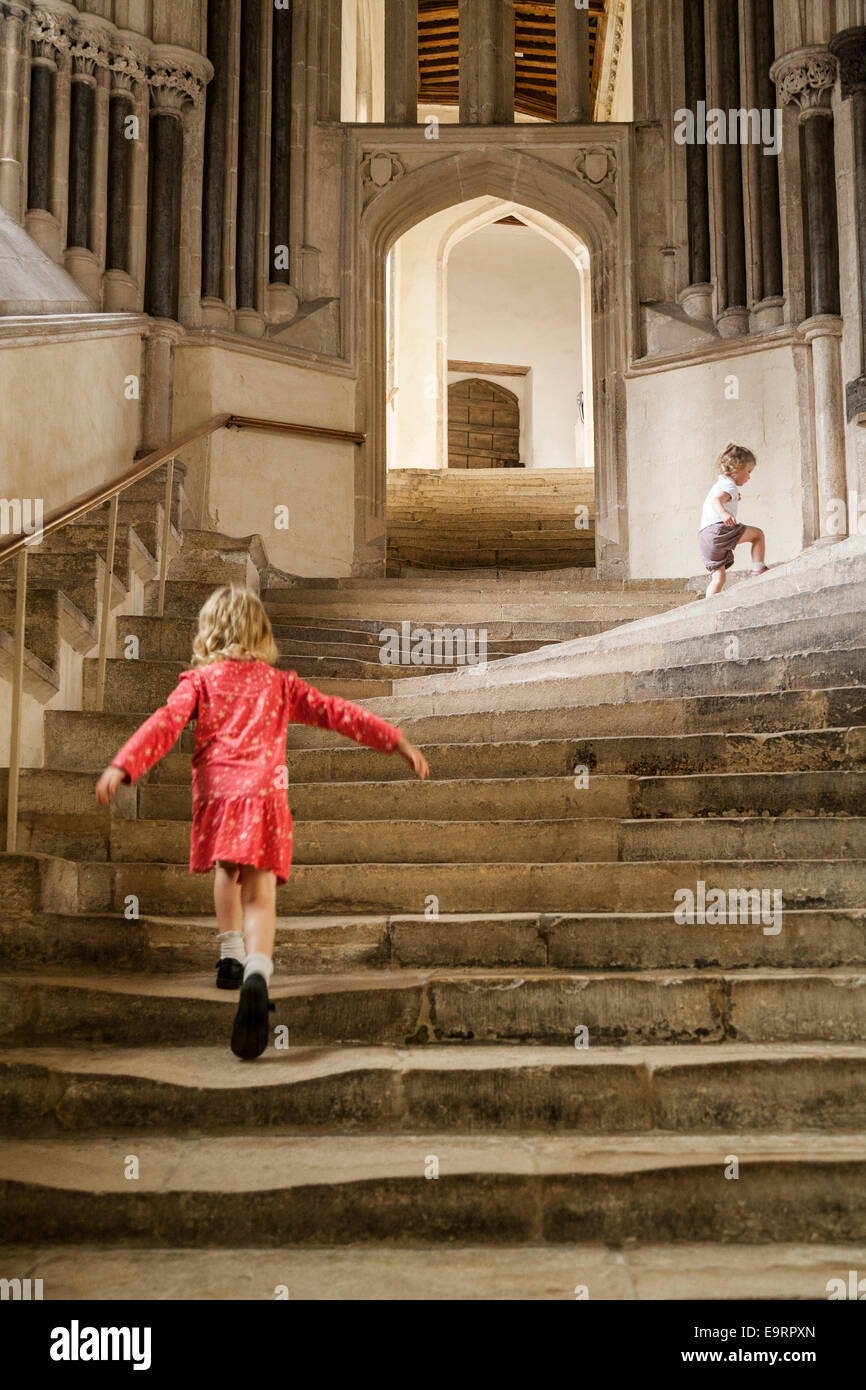 Fille enfant touristiques sur marches en pierre de la cathédrale de Wells ; étapes qui mènent à la Salle Capitulaire / Chapter House. Wells, Somerset. UK Banque D'Images